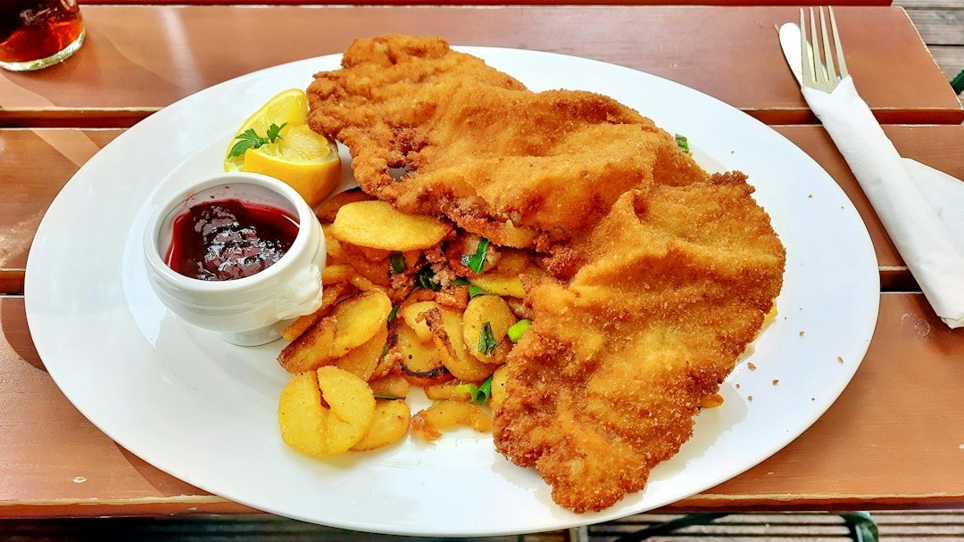 Złocisty panierowany kotlet na talerzu, zdjęcie ilustracyjne