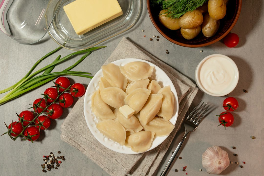 Ugotowane pierogi podane z dodatkami na talerzu